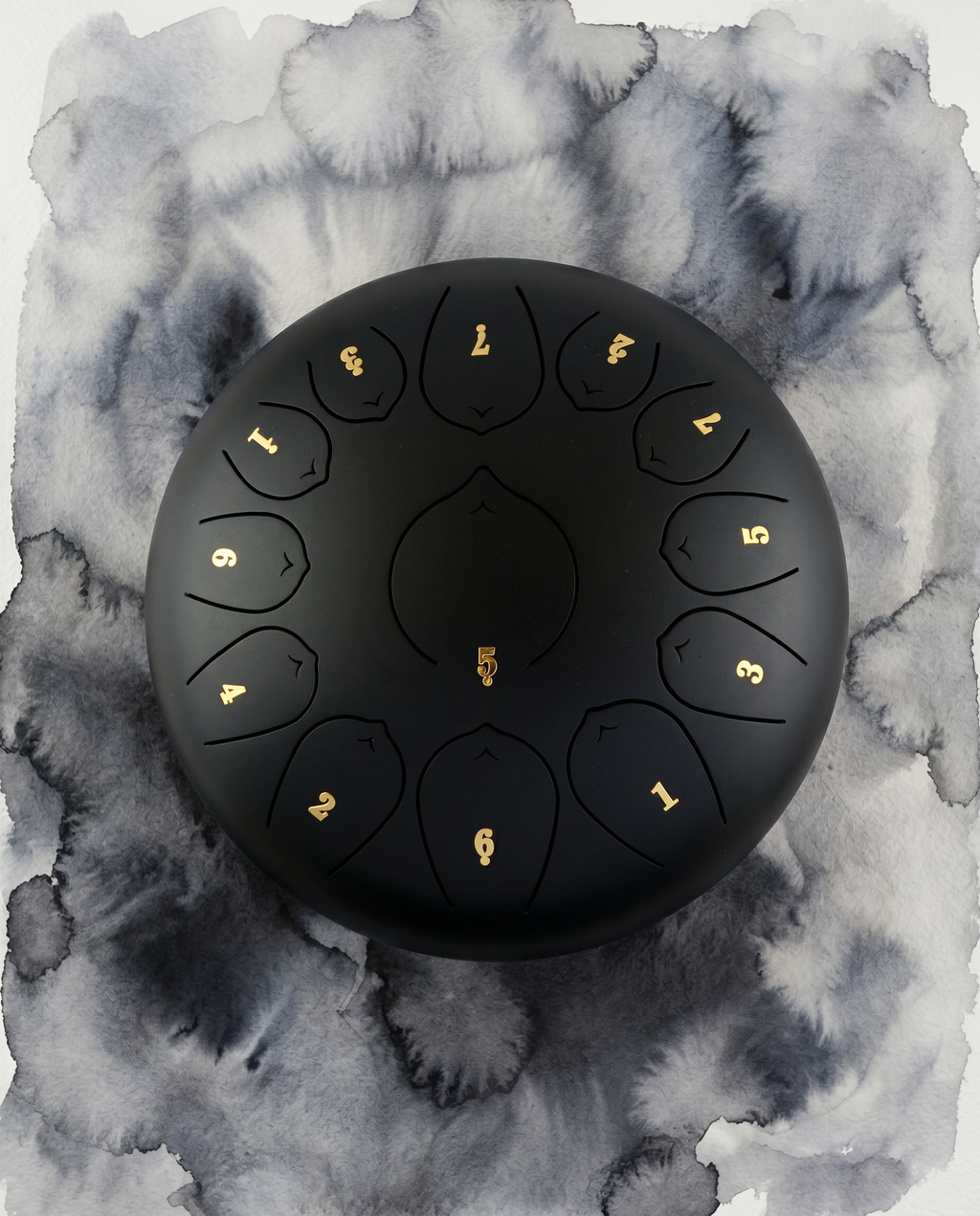 ` Black Ethereal 12-inch steel tongue drum with numbered notes beneath an ethereal water color sky.