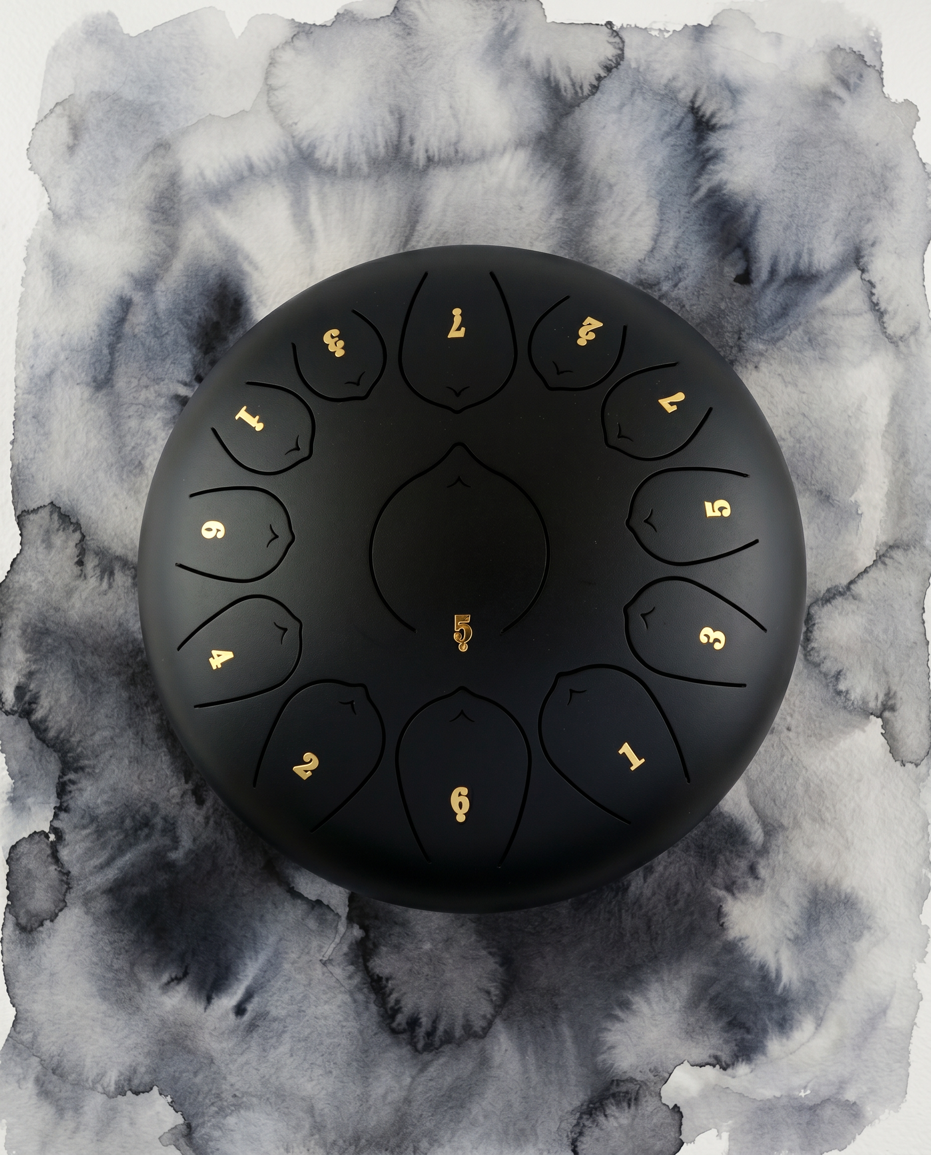 ` Black Ethereal 12-inch steel tongue drum with numbered notes beneath an ethereal water color sky.