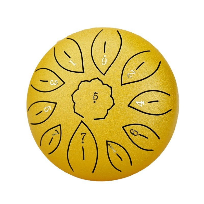 `Golden Ethereal 6-inch steel tongue drum with numbered notes in a vibrant world-city street scene.`
